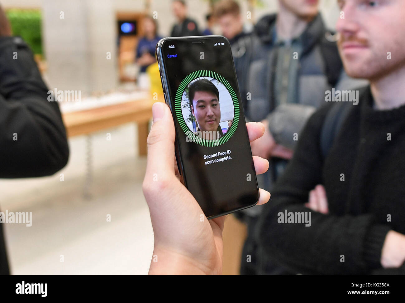 Un uomo utilizza la funzione di riconoscimento facciale su un iPhone X nell'Apple Store di Regent Street, Londra, mentre il nuovo telefono è andato in vendita nel Regno Unito. Foto Stock