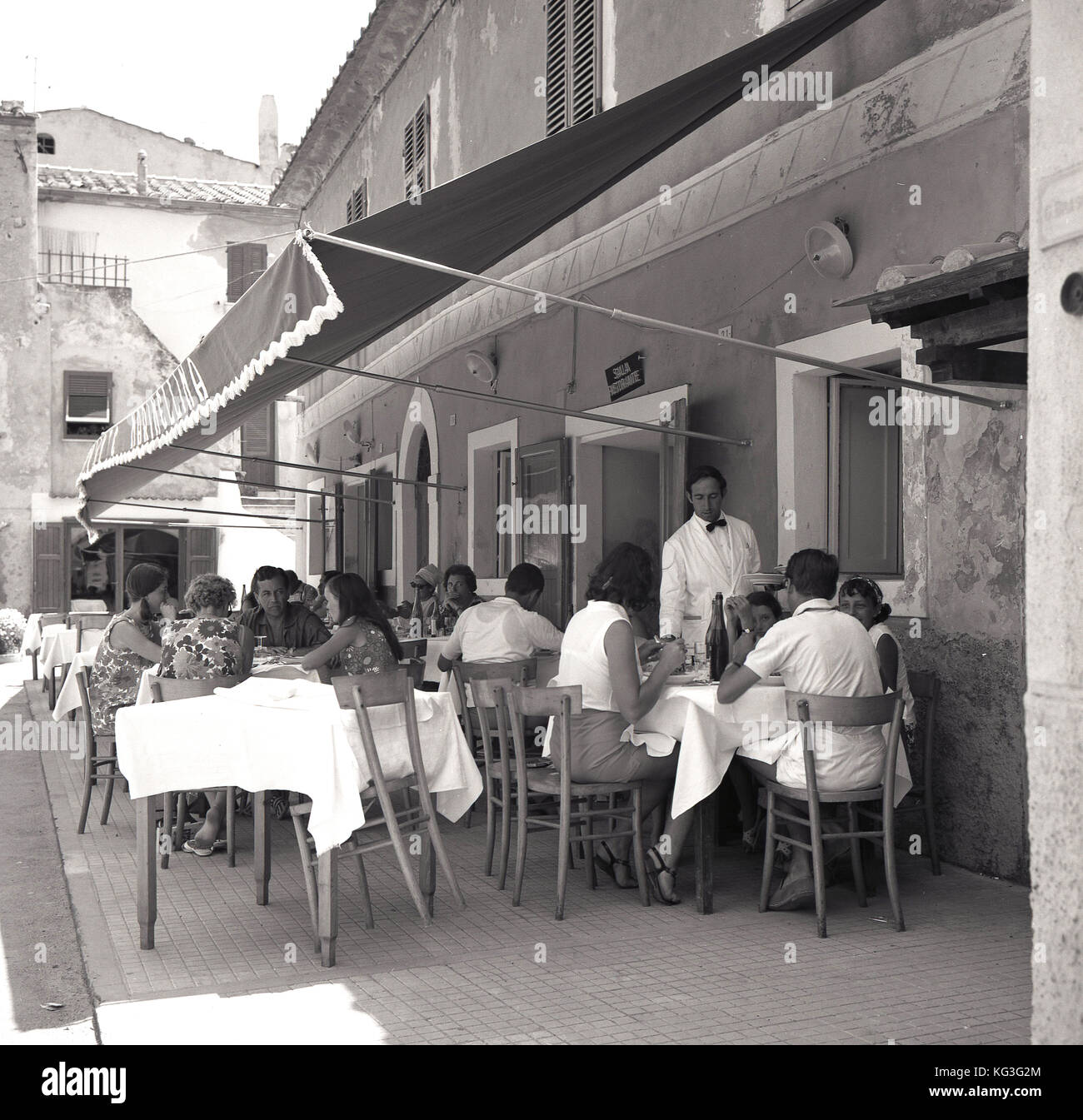 Degli anni Cinquanta, storico, famiglie godendo il pranzo al di fuori di un ristorante italiano a Napoli, Italia. Foto Stock