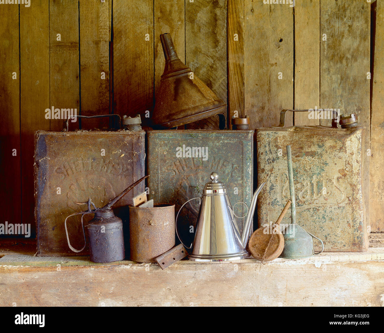 Ancora in vita. Benzina di antiquariato e lattine di olio sul ripiano di garage. Foto Stock