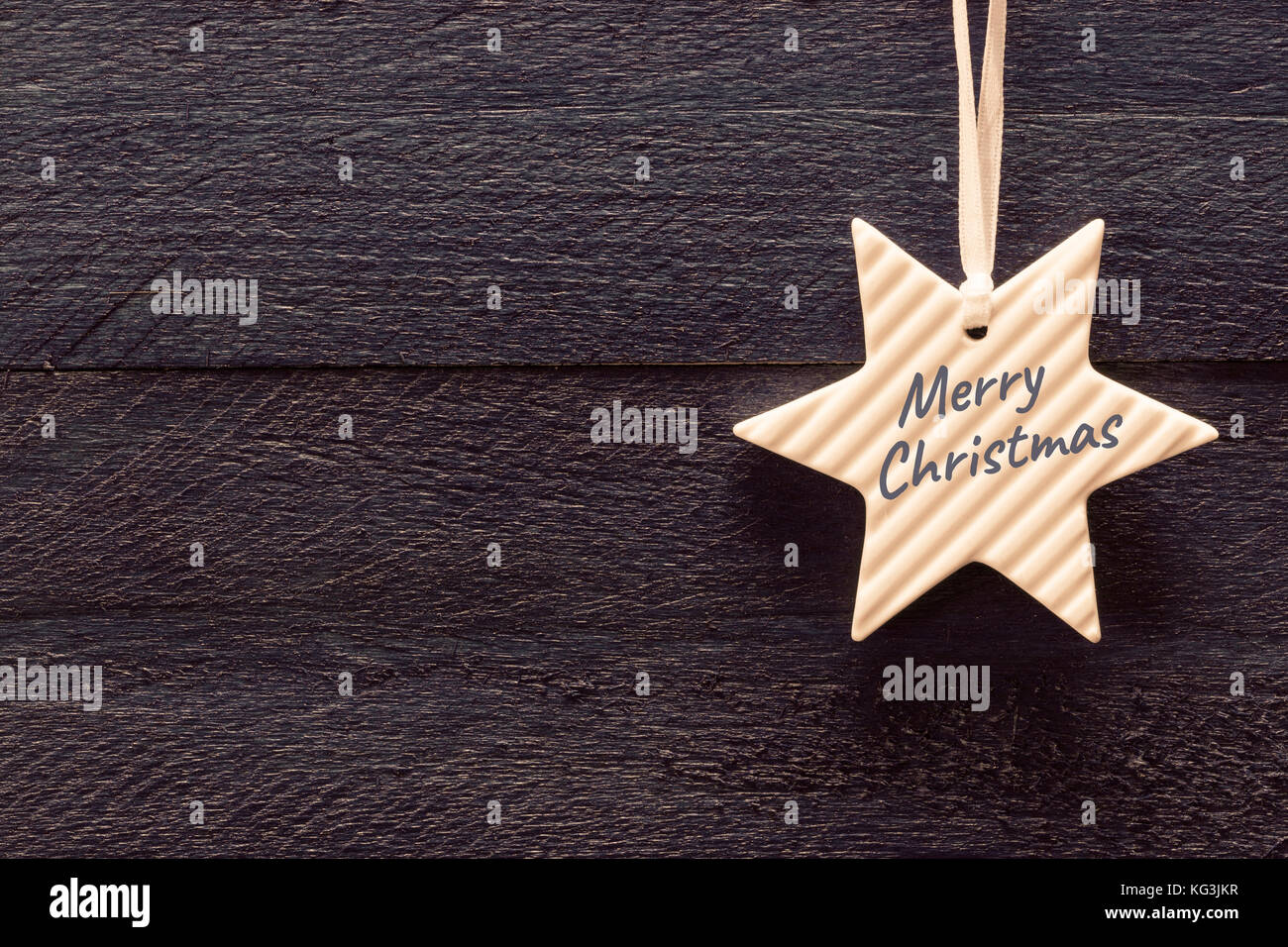 Merry Christmas card con stella nella parte anteriore del legno scuro. Foto Stock