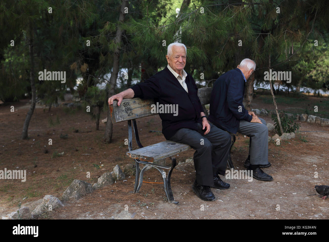 Atene Grecia Giardini Nazionali greche uomini anziani seduti in panchina Foto Stock
