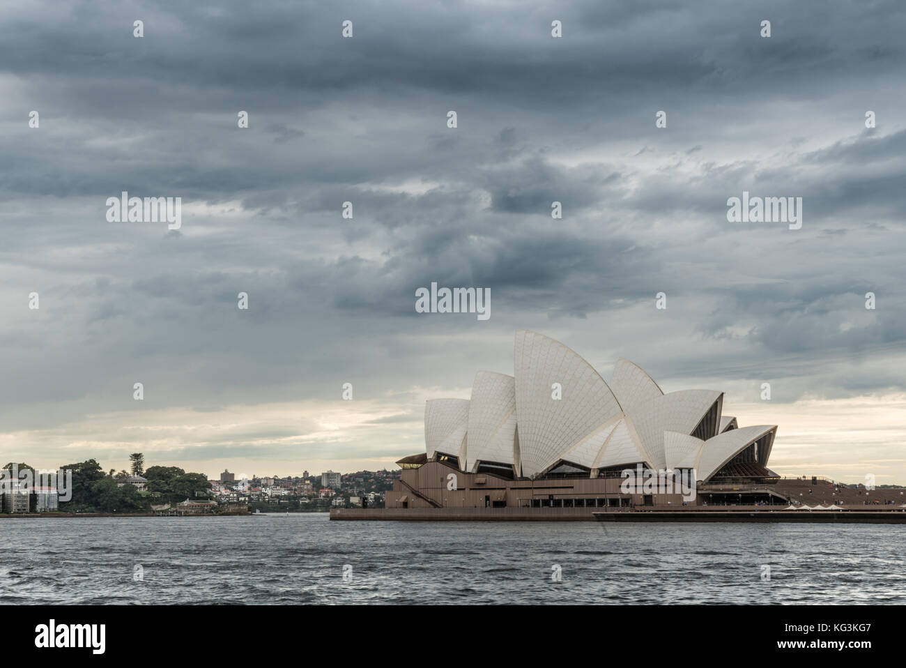 Sydney, Australia - 22 marzo 2017: il lato ovest della opera house sulla sua penisola circondata dalle acque del porto, sotto pesante nuvoloso tempestoso cloudscape. Foto Stock