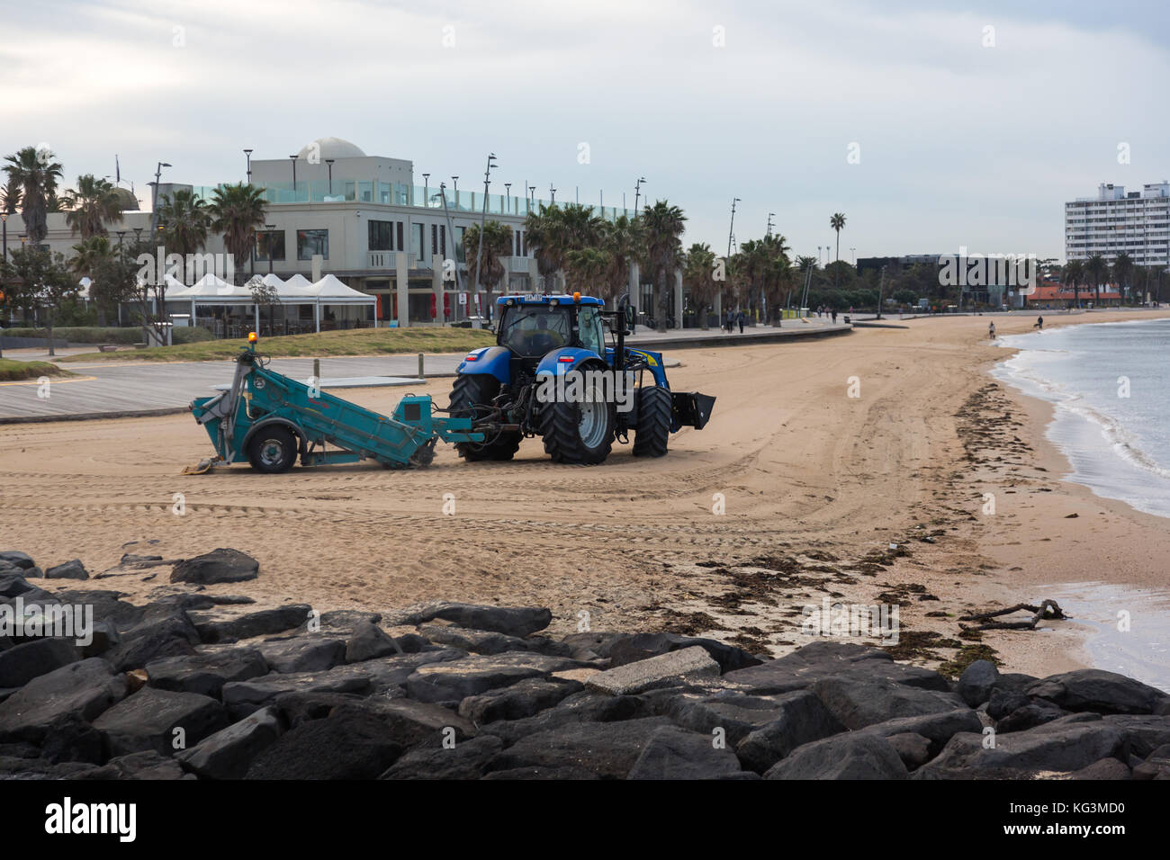 Un trattore pettinatura della sabbia per i rifiuti presso la spiaggia di St Kilda, Victoria. Australia. Foto Stock
