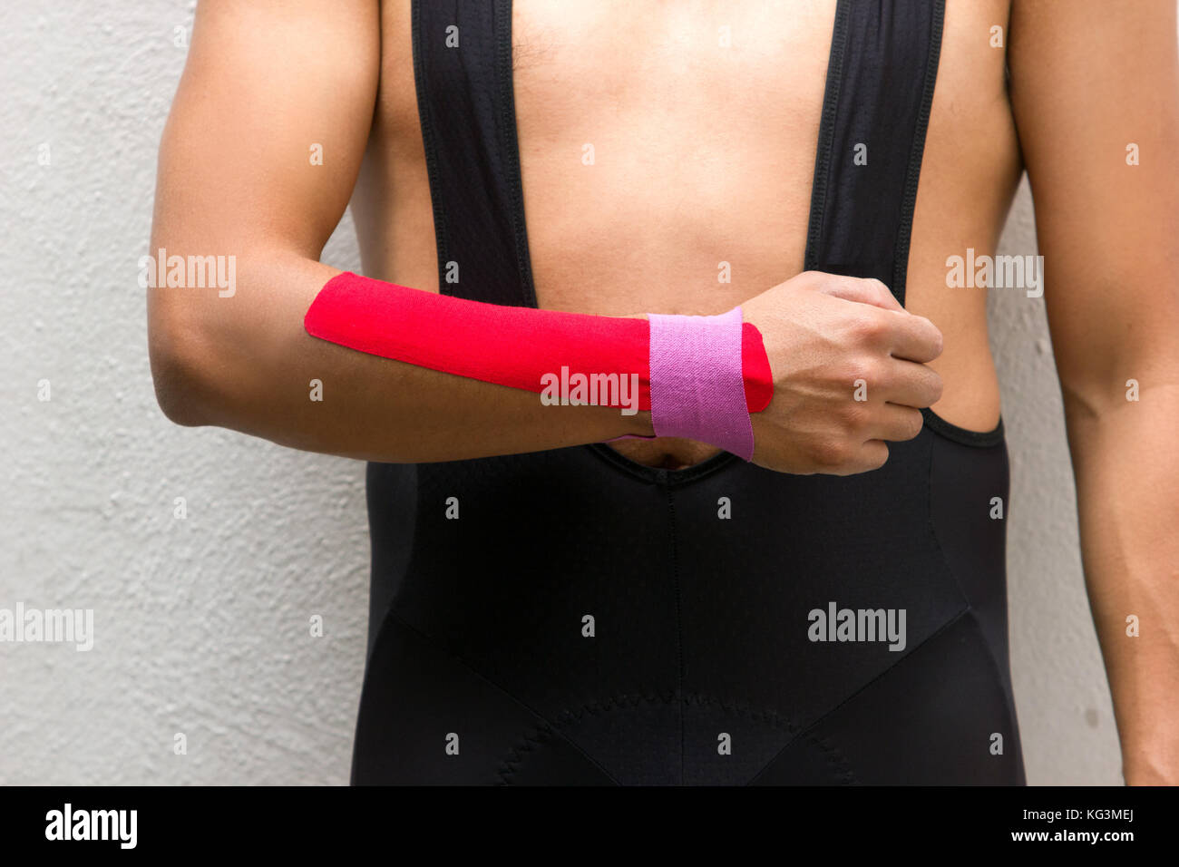 La foto in orizzontale di un ciclista maschio con nastro kinesio sul suo braccio e polso per ridurre il dolore Foto Stock
