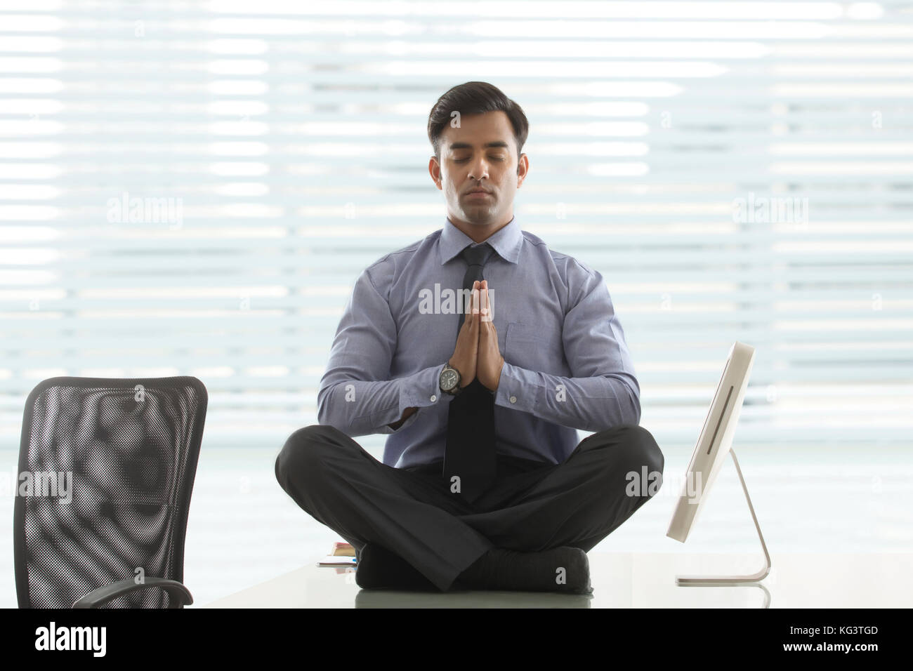 Imprenditore meditando sulla scrivania in ufficio Foto Stock