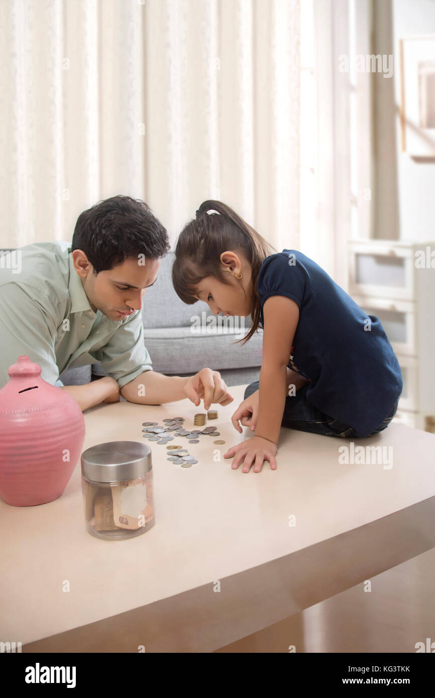 Padre e figlia contando salvadanaio monete Foto Stock