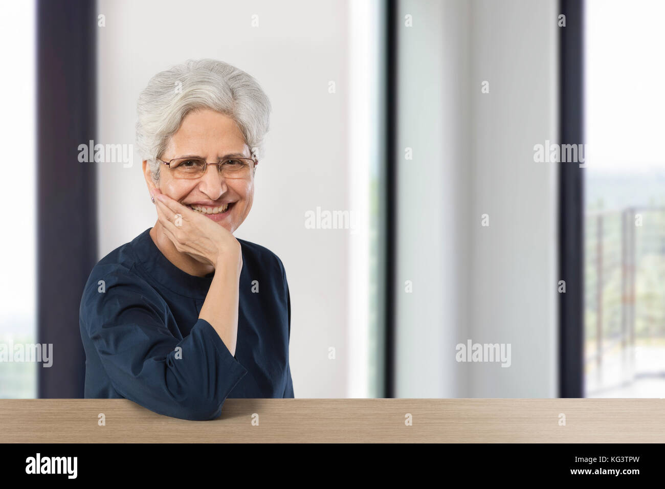 Felice senior donna con la mano sul mento Foto Stock