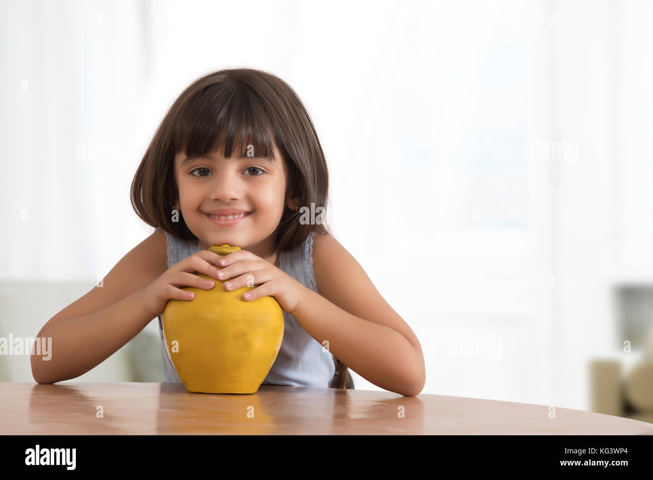 Ritratto di sorridente bambina azienda argilla salvadanaio Foto Stock