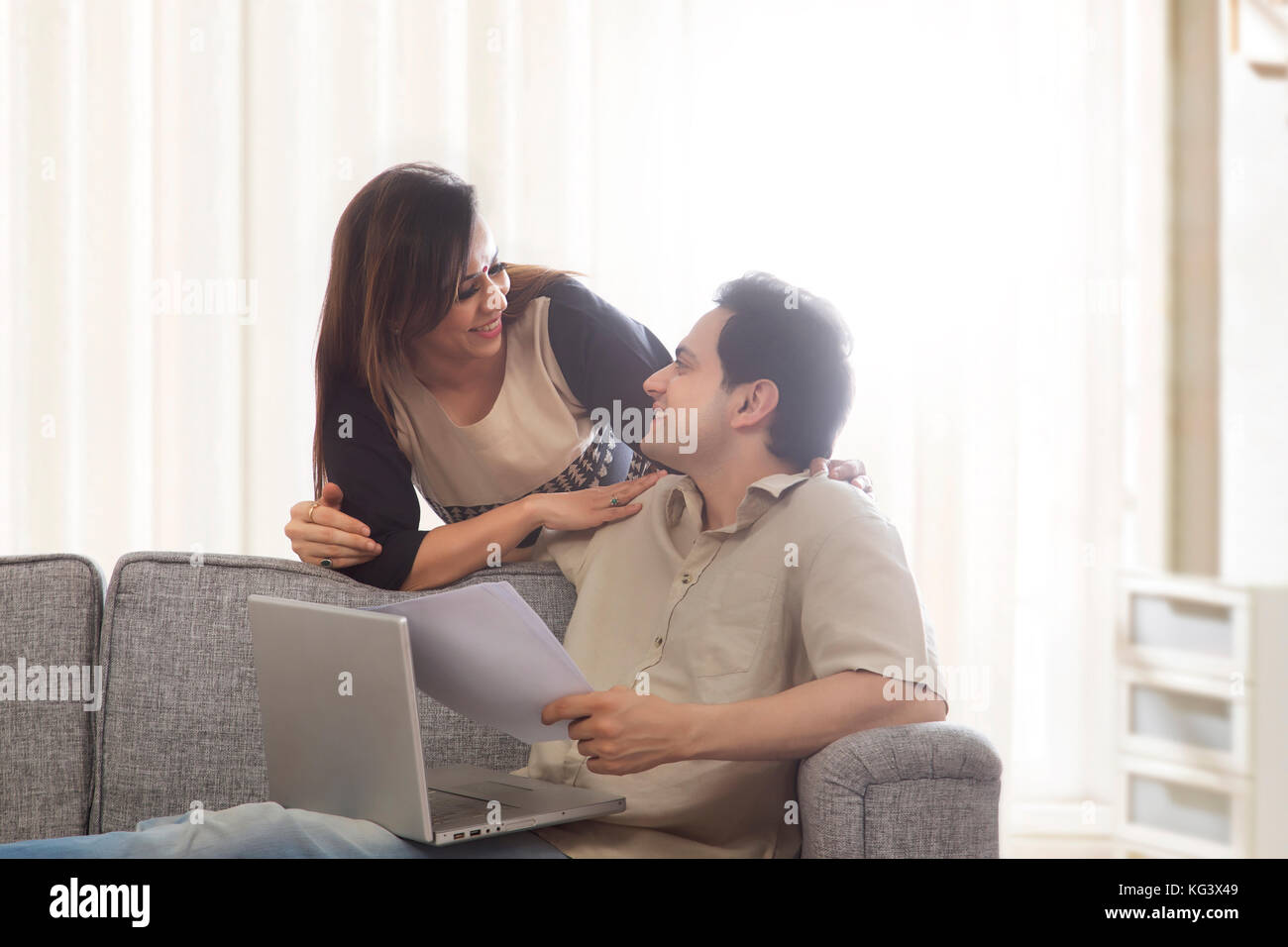 Giovane guardando ogni altra con laptop e carte Foto Stock