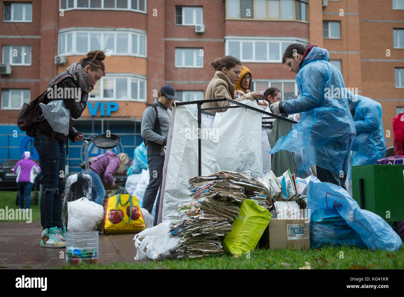 I volontari raccolgono rifiuti domestici per il riciclaggio in una piazza nella città di Zheleznodorozhny, provincia di Mosca, Russia. Gli abitanti locali hanno smistato i rifiuti in anticipo a casa nelle settimane precedenti e possono lasciarli in sacchetti o contenitori separati per ulteriori trasporti e riciclaggio altrove. Per ora, i volontari vengono qui una volta al mese, ma l'idea guadagna popolarità. Lo smistamento dei rifiuti è ancora raro in Russia, dove circa il novanta per cento dei rifiuti domestici finisce in enormi discariche aperte. Foto Stock