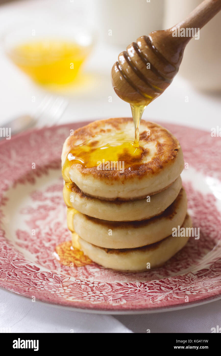 Cottage cheese pancakes, syrniki fatti in casa con il miele e panna acida. Foto Stock