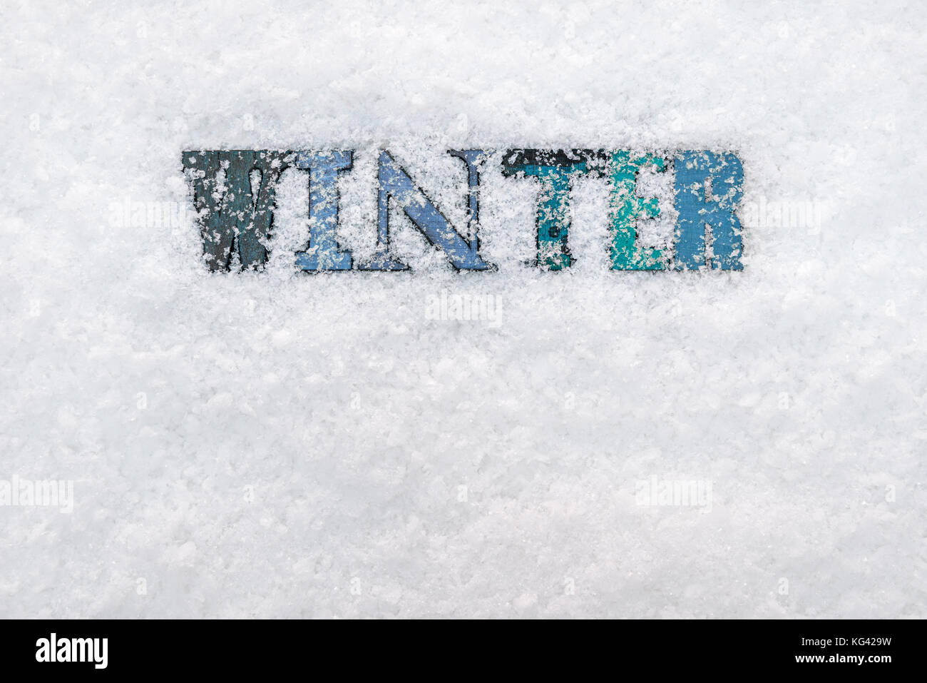 La parola inverno realizzato dalla boscosa lettere in rilievo su uno sfondo di neve Foto Stock