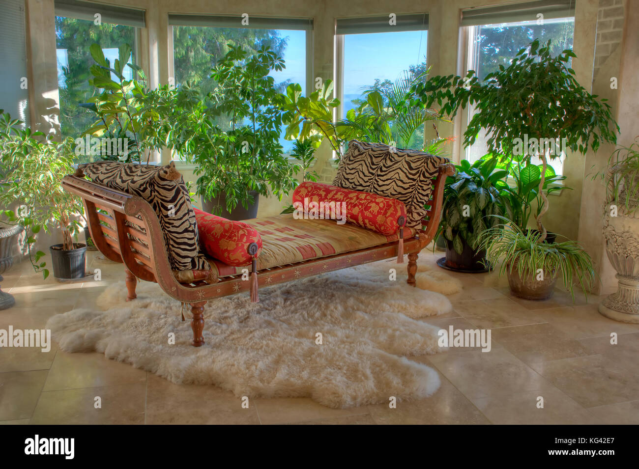 Questa è una casa di lusso interno con una chaise longue, piante, pavimento in piastrelle e splendide finestre. Foto Stock
