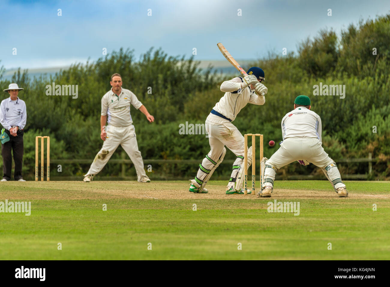 Un battitore gioca un colpo durante una domenica League match tra due locali squadre di cricket. Foto Stock