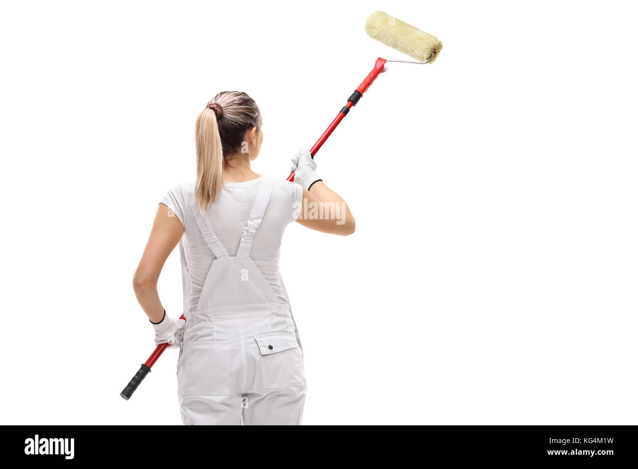 Ripresa posteriore di una femmina di pittore pittura con un rullo di vernice isolati su sfondo bianco Foto Stock