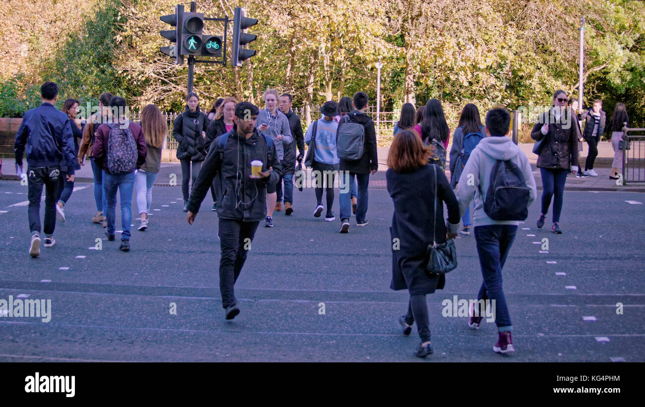 Gli studenti della strada di attraversamento al semaforo verde a piedi man street dumbarton road glasgow university Foto Stock