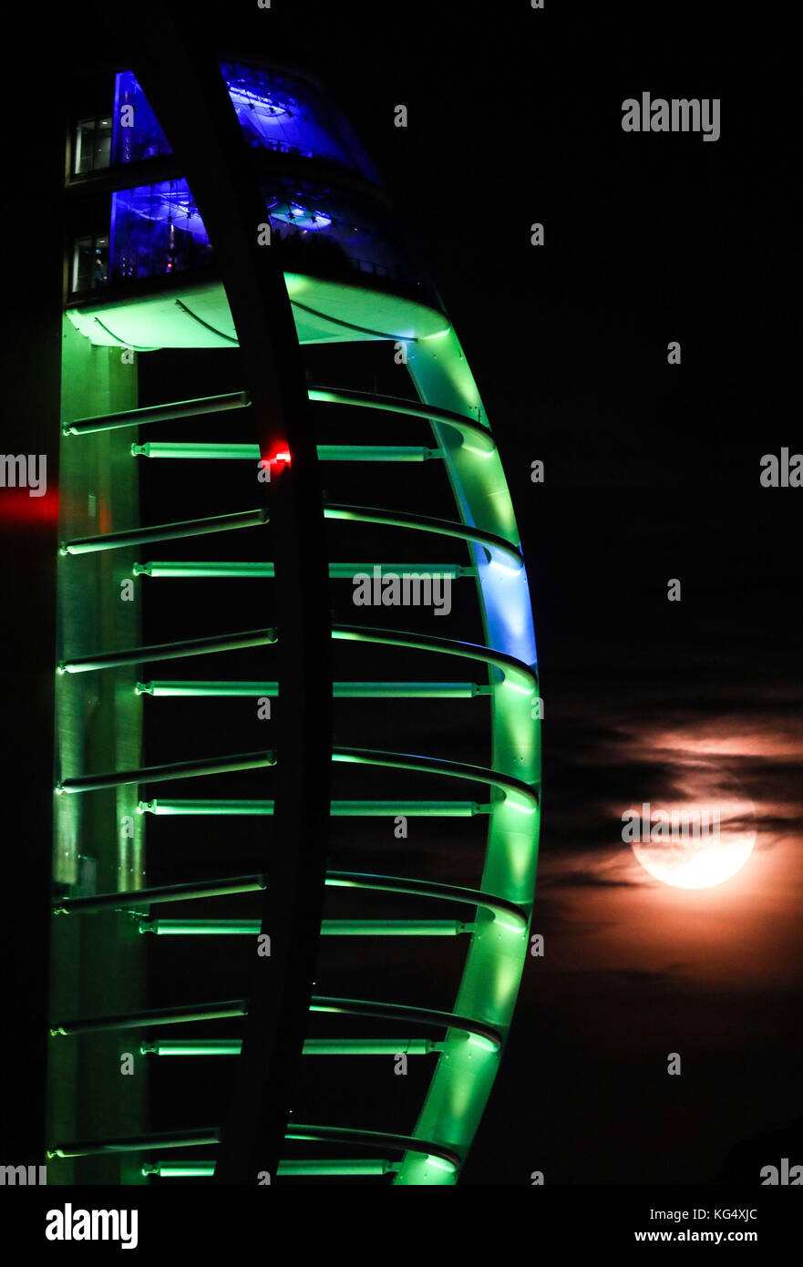 Una luna quasi piena di novembre, conosciuta come Beaver o Luna di Cacciatori secondo i nativi nordamericani, sorge dietro la Spinnaker Tower a Portsmouth, Hampshire. Foto Stock