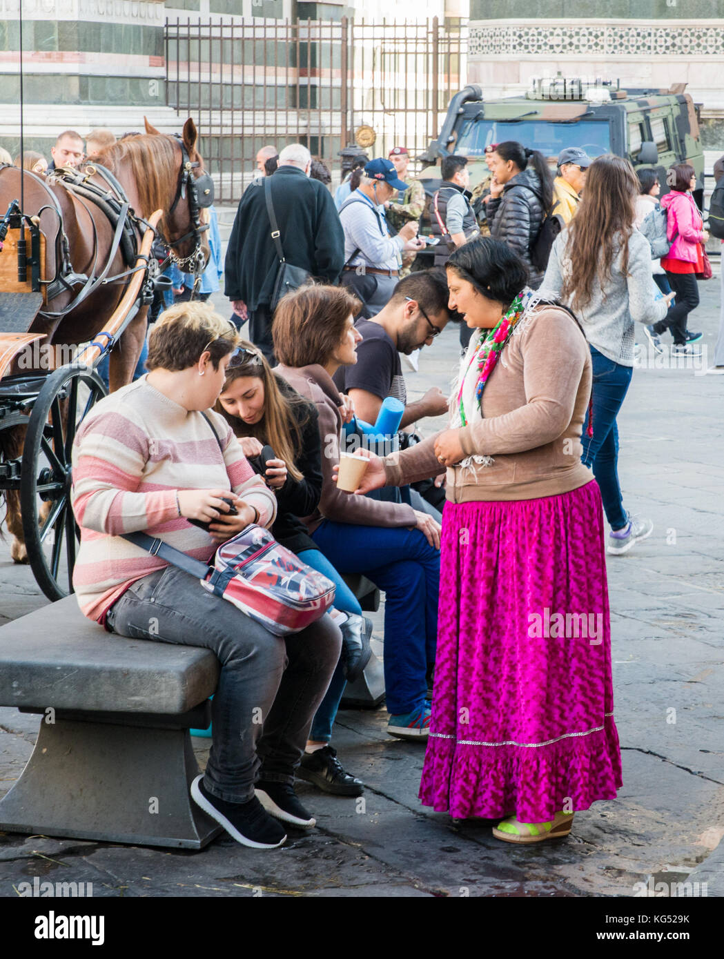Gypsie donna chiede con successo i turisti di fronte al Duomo di Firenze in Toscana, Italia Foto Stock