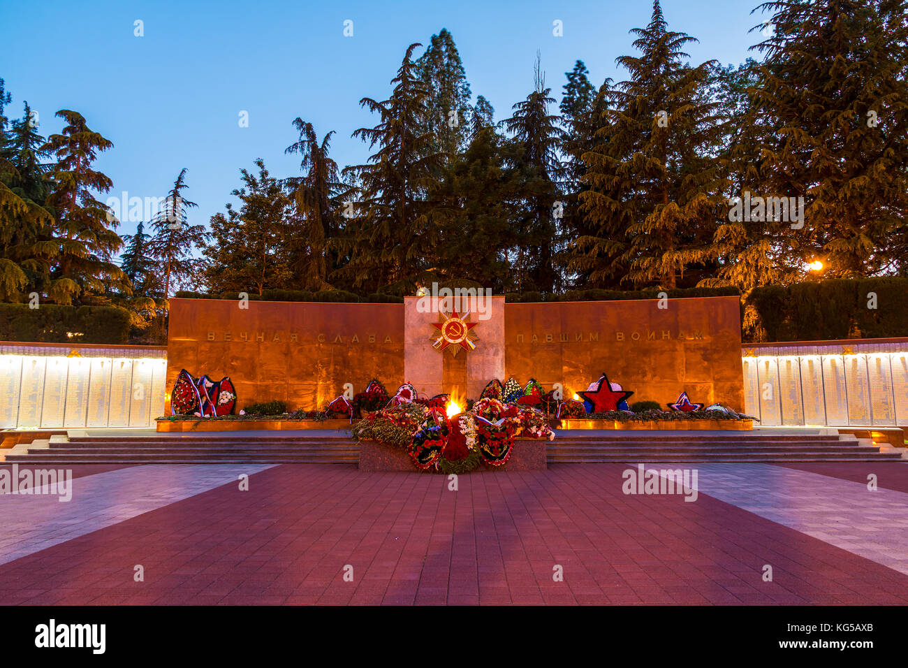 La fiamma eterna di zavokzalnyy complesso memoriale al crepuscolo, Sochi, Russia. tradurre del testo è "gloria eterna ai caduti' Foto Stock