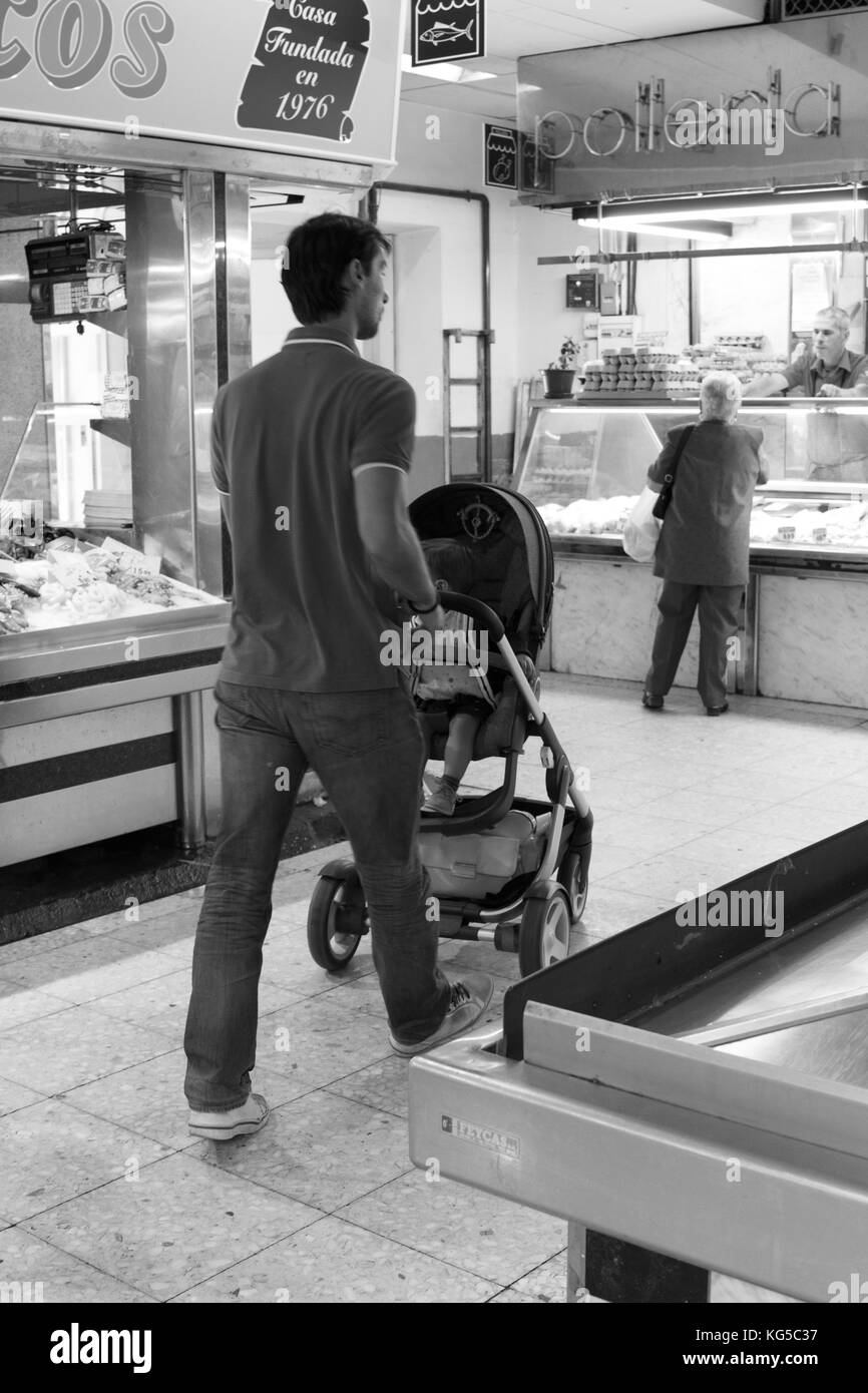 Uomo che cammina attraverso il mercato con il suo piccolo ragazzo Foto Stock