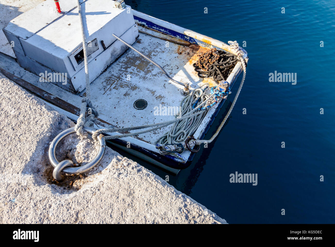 Al di sopra di vista ancorata sulla piccola barca da pesca che è legato con la fune a un moor presso la porta locale. Foto Stock