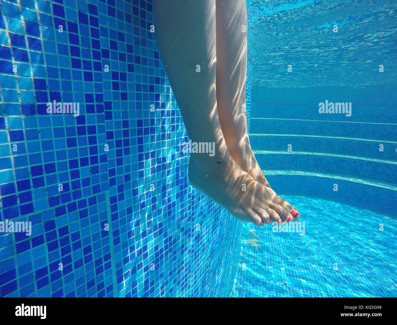 Riprese subacquee donne gambe in piscina. La vacanza estiva. Foto Stock