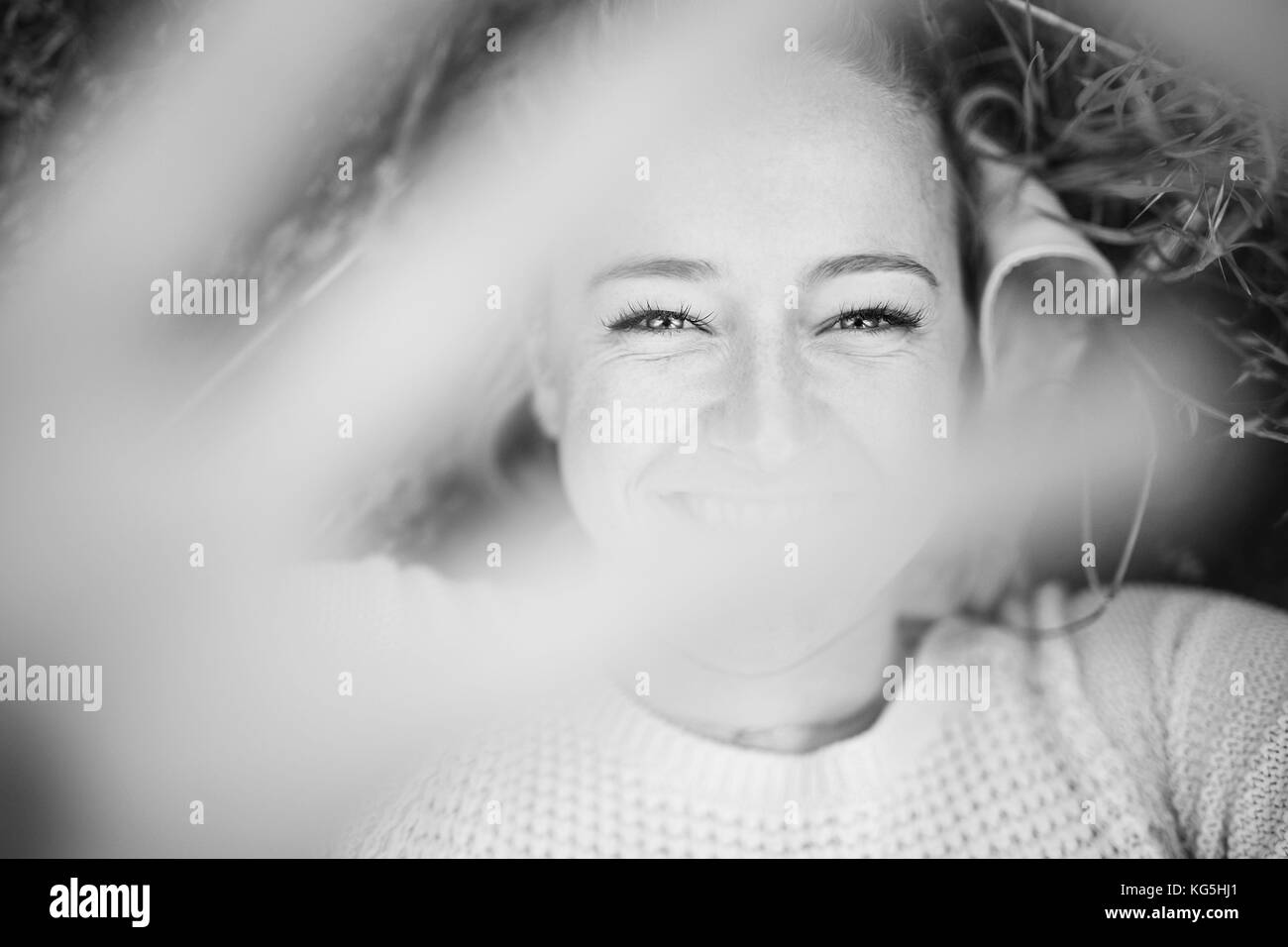 Giovane donna sorridente in natura, tenendo la mano nella parte anteriore della fotocamera, b / W Foto Stock