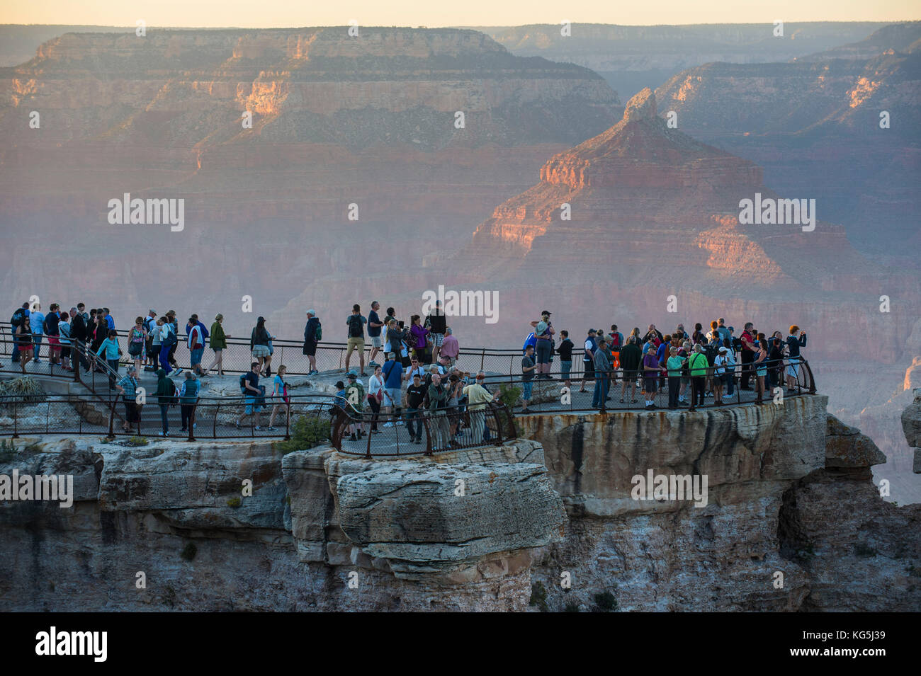 I turisti a guardare il tramonto su una piattaforma di oltre il Grand Canyon, Arizona, Stati Uniti d'America Foto Stock