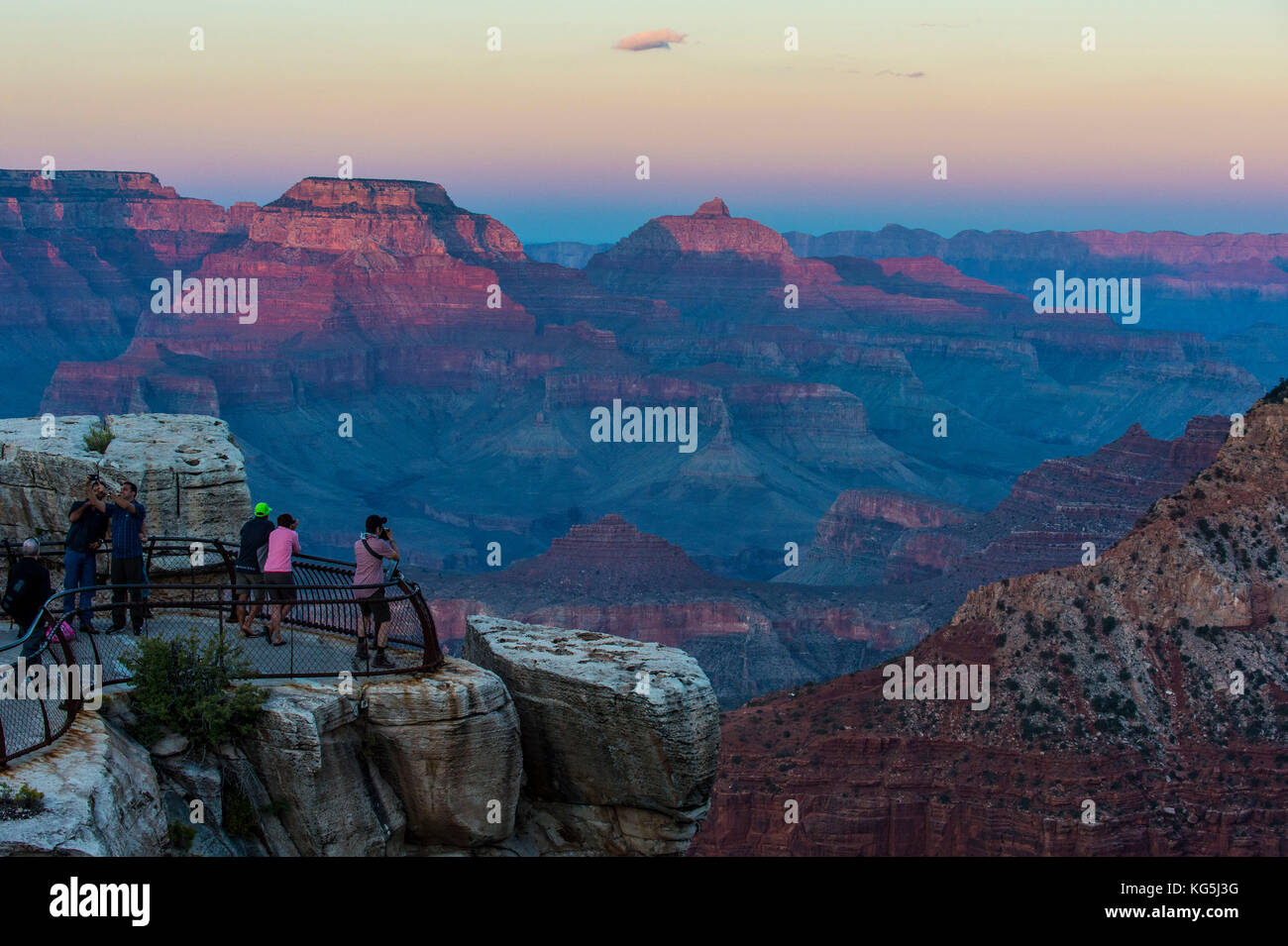 I turisti a guardare il tramonto su una piattaforma di oltre il Grand Canyon, Arizona, Stati Uniti d'America Foto Stock