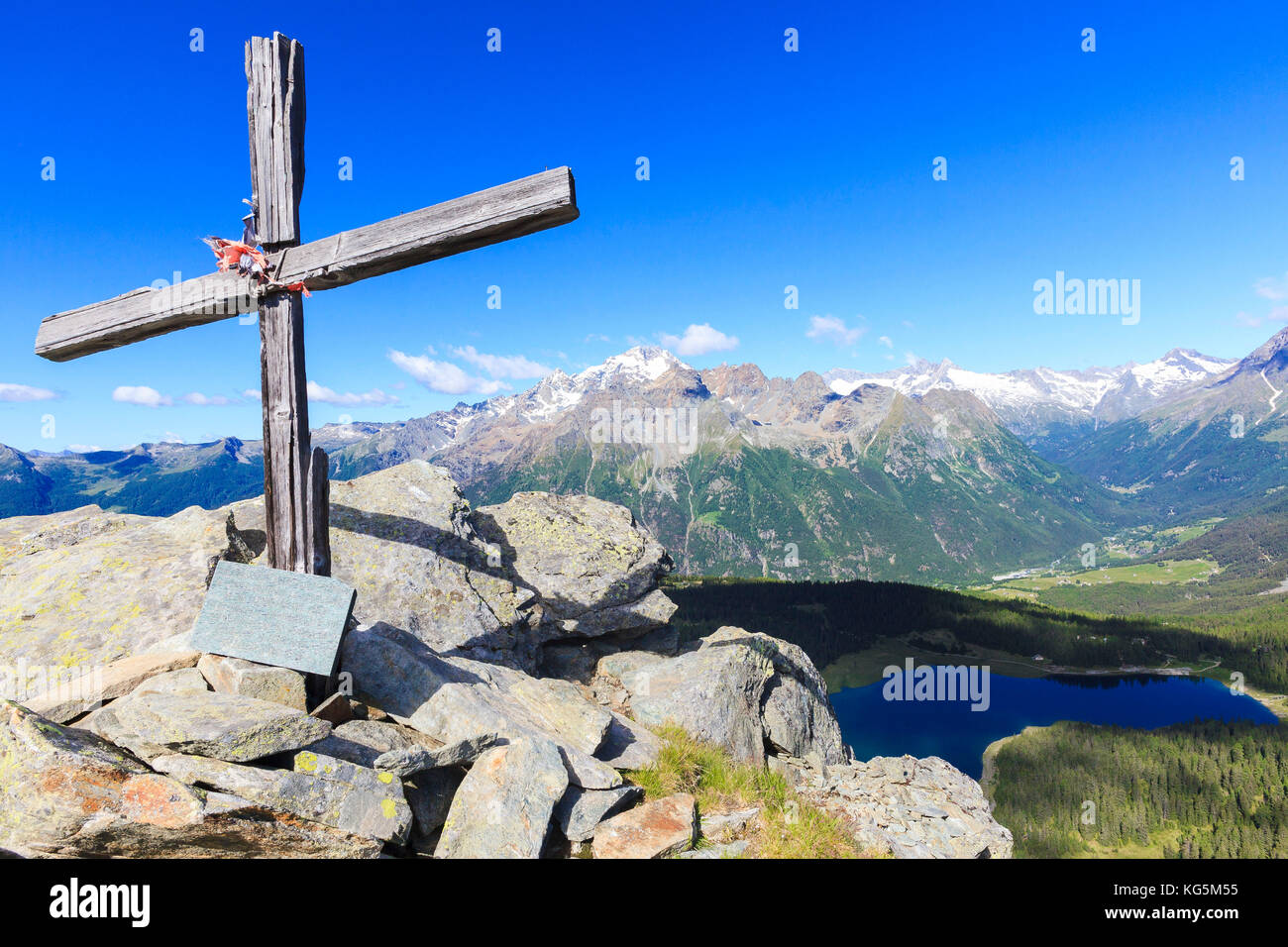 Croce di legno sopra il lago Palù incorniciato dal monte Disgrazia visto dal Monte Roggione Malenco Valley Valtellina Lombardia Italia Europa Foto Stock