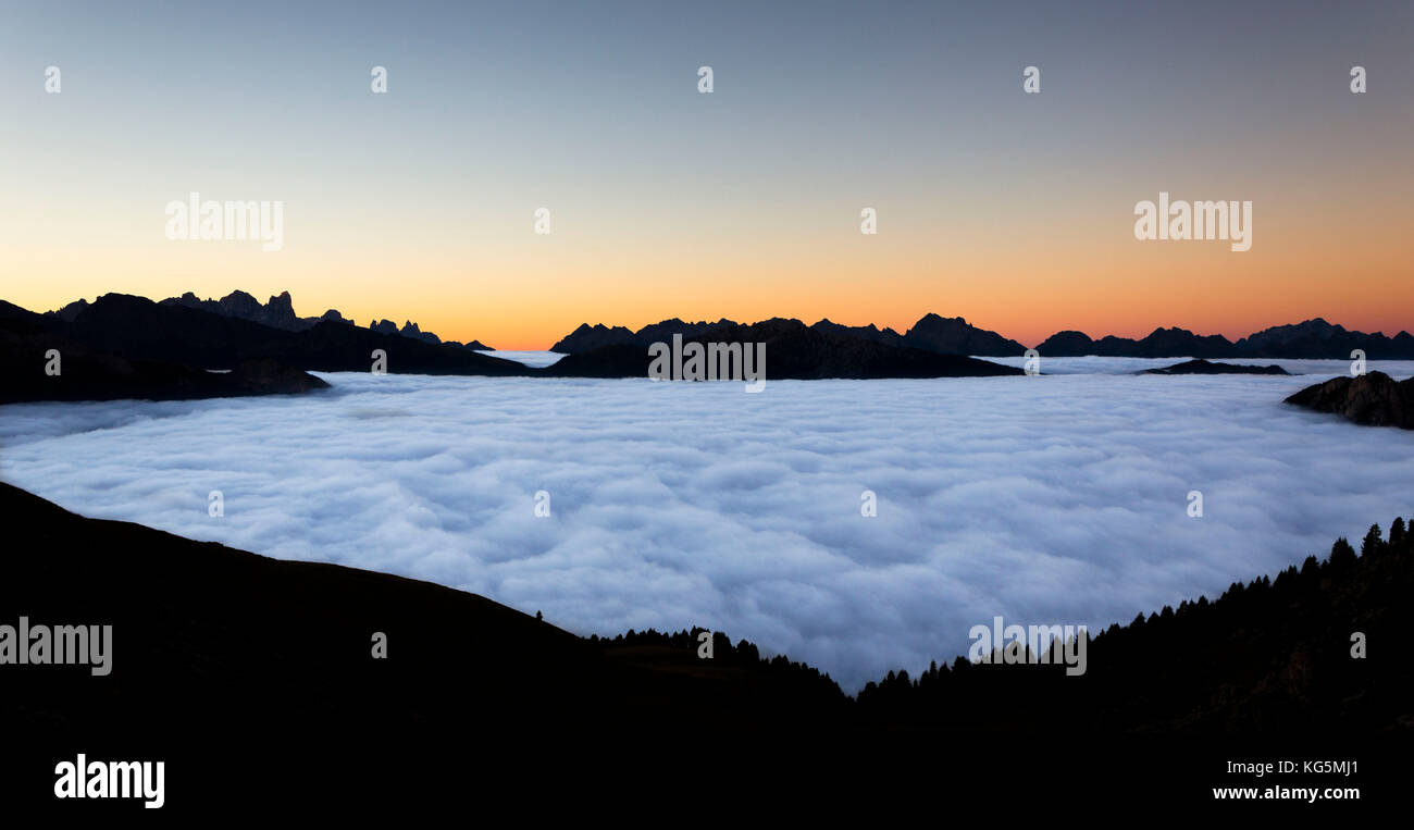 Un suggestivo tramonto dal gruppo del Catinaccio con tutta la valle di Fassa coperto dalle nuvole, provincia di Trento, trentino alto adige, italia Foto Stock