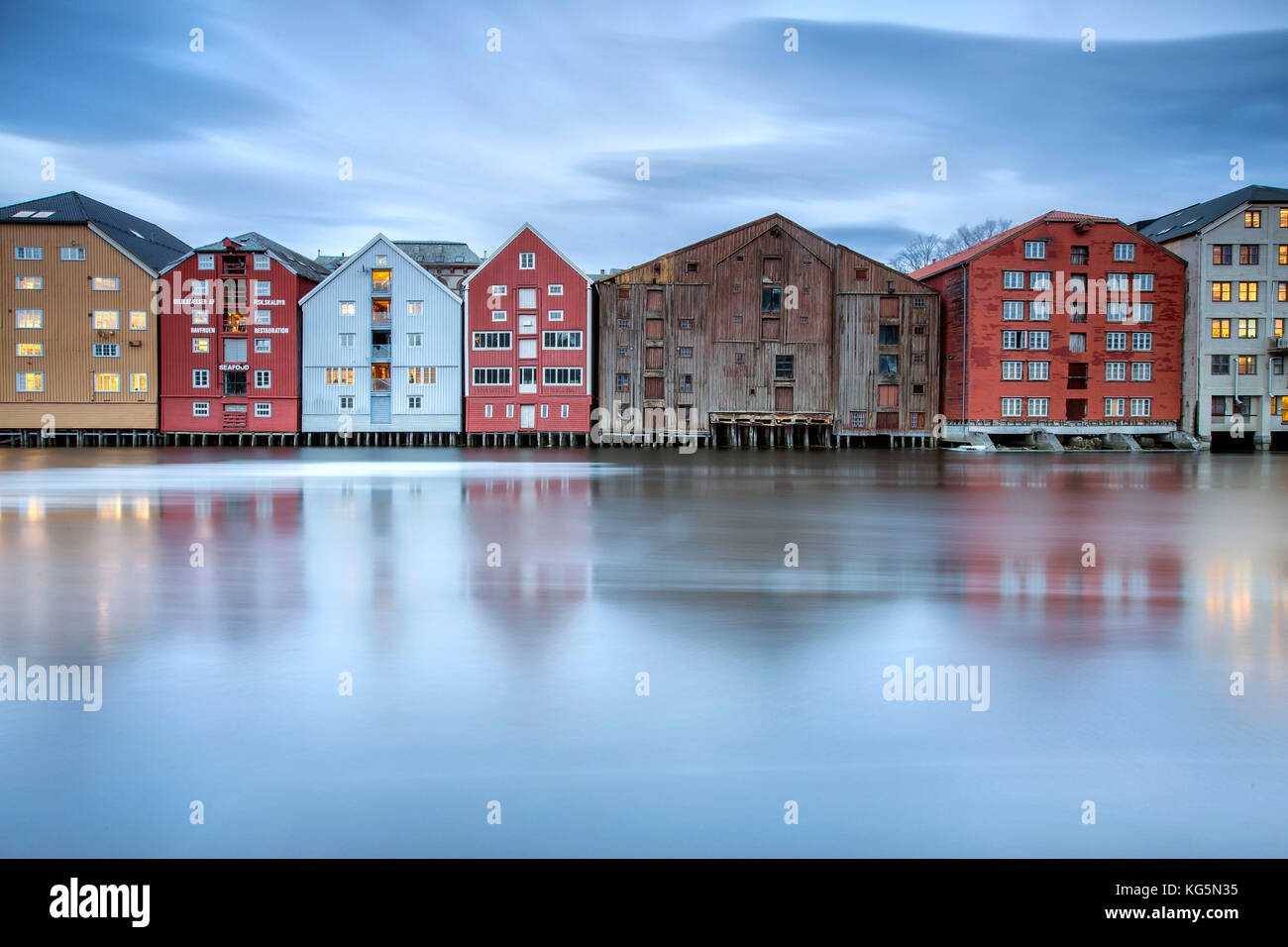 Case colorate sono riflessi nel fiume Nidelva Bakklandet Trondheim in Norvegia Europa Foto Stock