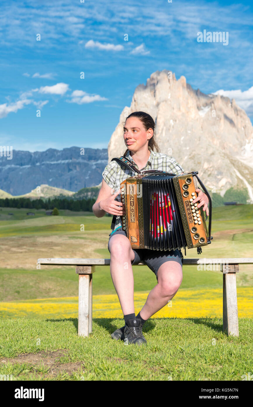 Alpe di Siusi, Dolomiti, Alto Adige, Italia. Giovane donna che suona con la fisarmonica all'Alpe di Siusi Foto Stock