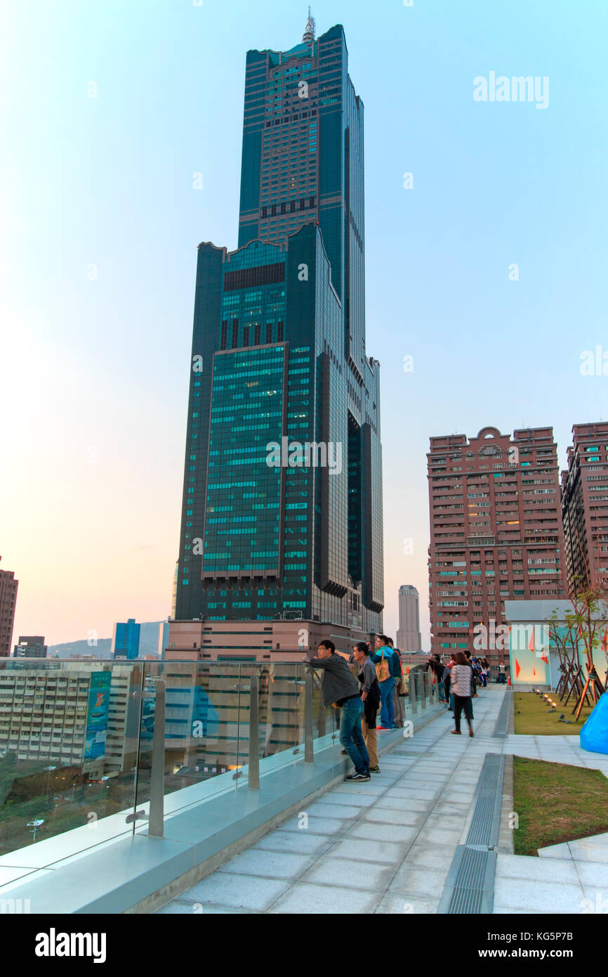 Kaohsiung, Taiwan. Le persone accanto a la Tuntex Sky Tower e guardare il tramonto . La struttura si trova a 378 m e alta. Costruito dal 1994 al 1997, è il grattacielo più alto di Kaohsiung, ed era il più alto di Taiwan fino al completamento di Taipei 101. Foto Stock