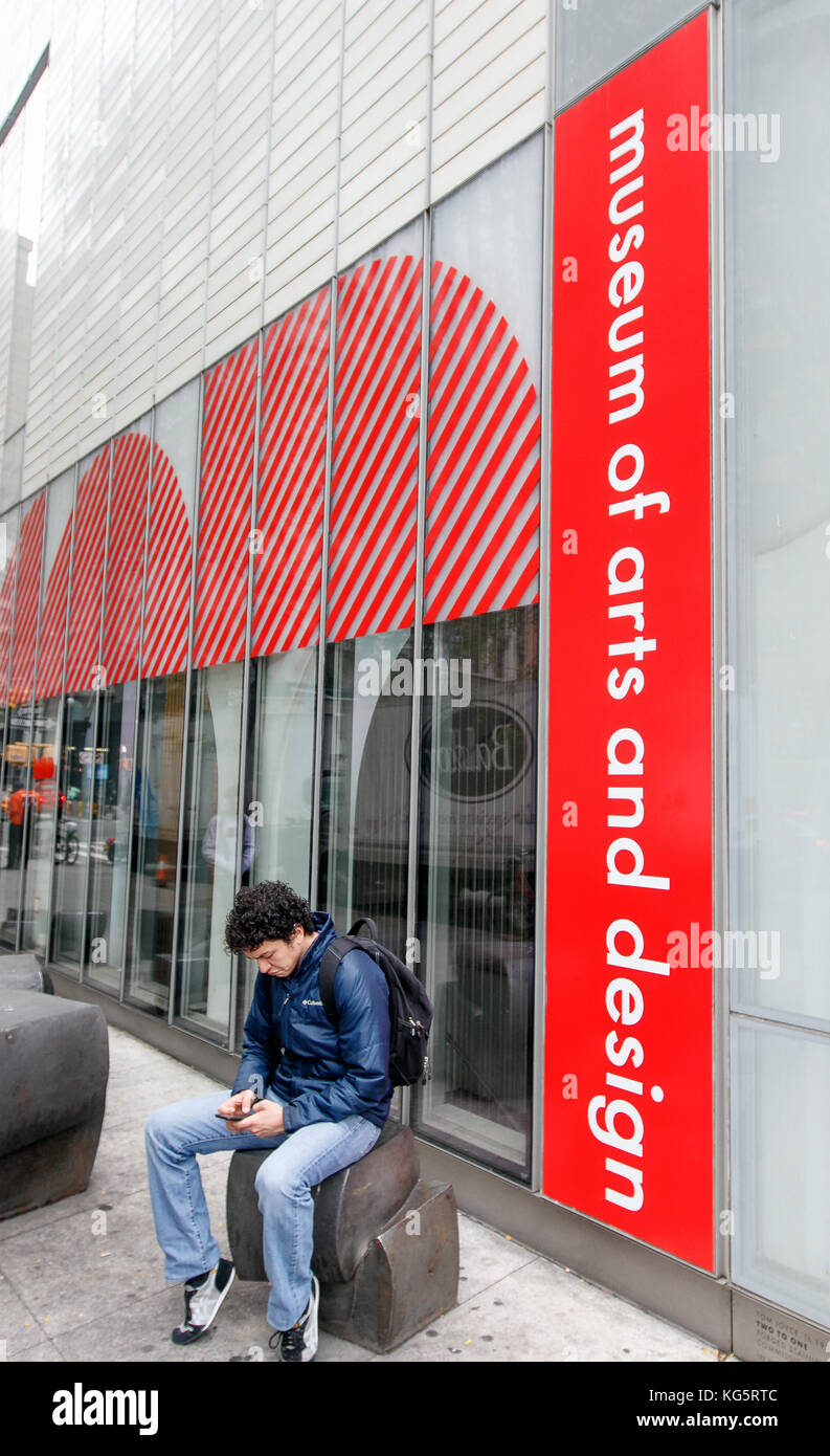 Giovane uomo è guardando al suo smartphone durante l udienza con il Museo delle Arti e Design a New York. Foto Stock