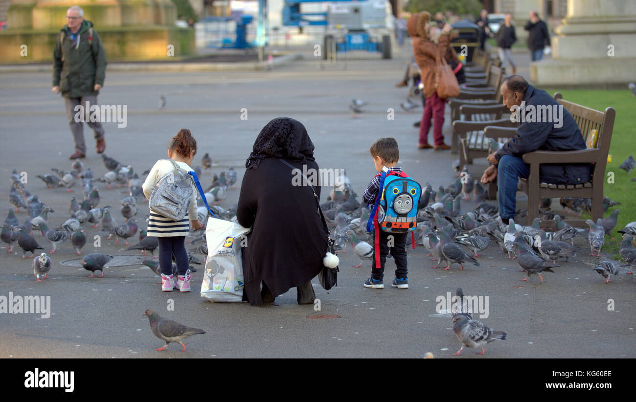 Famiglia asiatica rifugiato vestito hijab sciarpa su strada nel Regno Unito musulmana musulmano Foto Stock