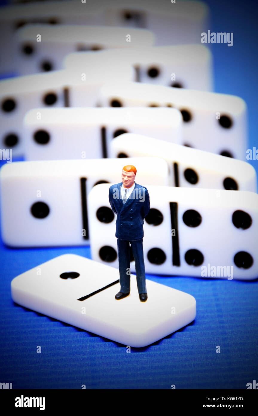 Imprenditore figurina in piedi su una piastrella di domino, leadership decisioni concept Foto Stock