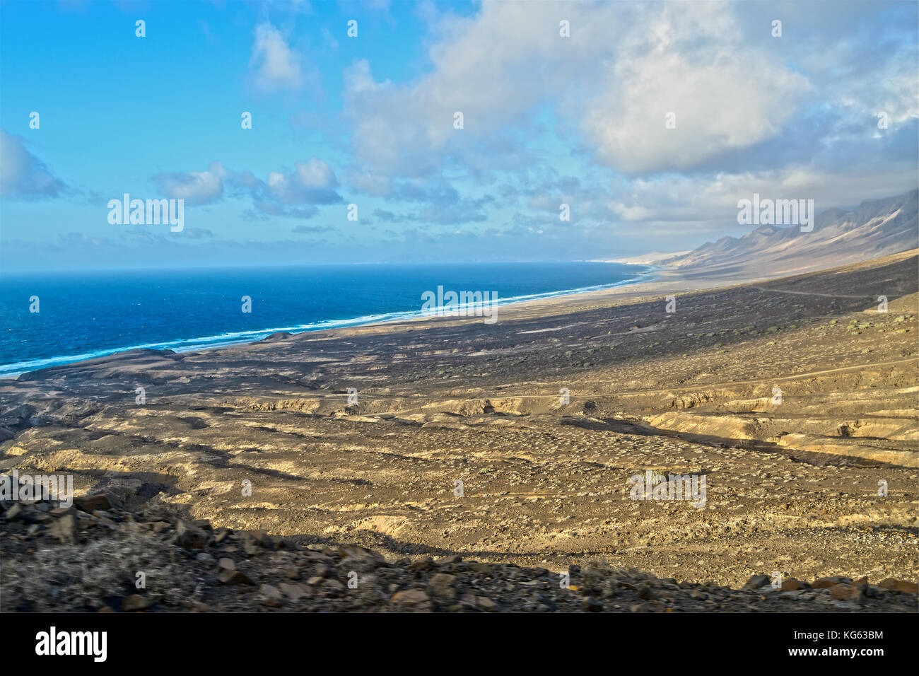 Spiaggia di Cofete con il suo entroterra composto da rocce vulcaniche e terreno arido, Fuerteventura, Isole Canarie, Spagna Foto Stock