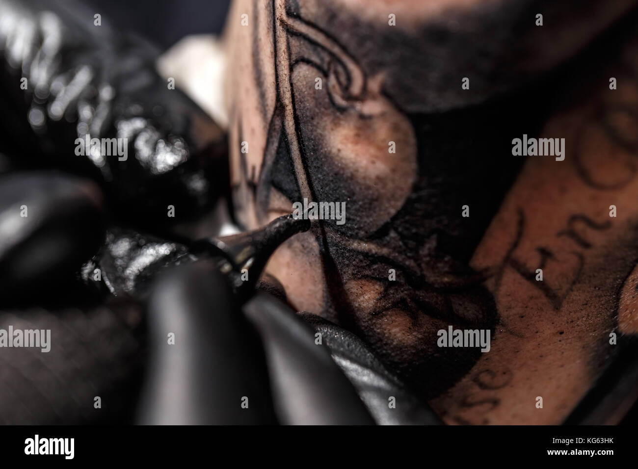 Un professional tattoo artist introduce l'inchiostro nero in pelle utilizzando un ago da un dermografo. Foto Stock