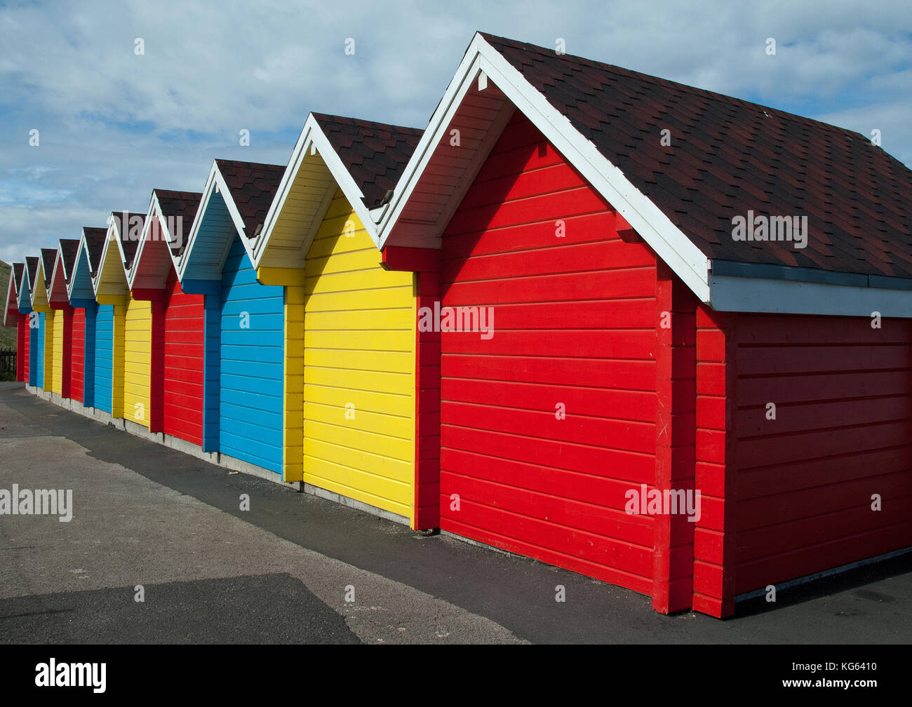 Vista posteriore di una fila di gable coperto spiaggia britannico di capanne con ogni capanna singolarmente dipinte in rosso, giallo o blu Foto Stock