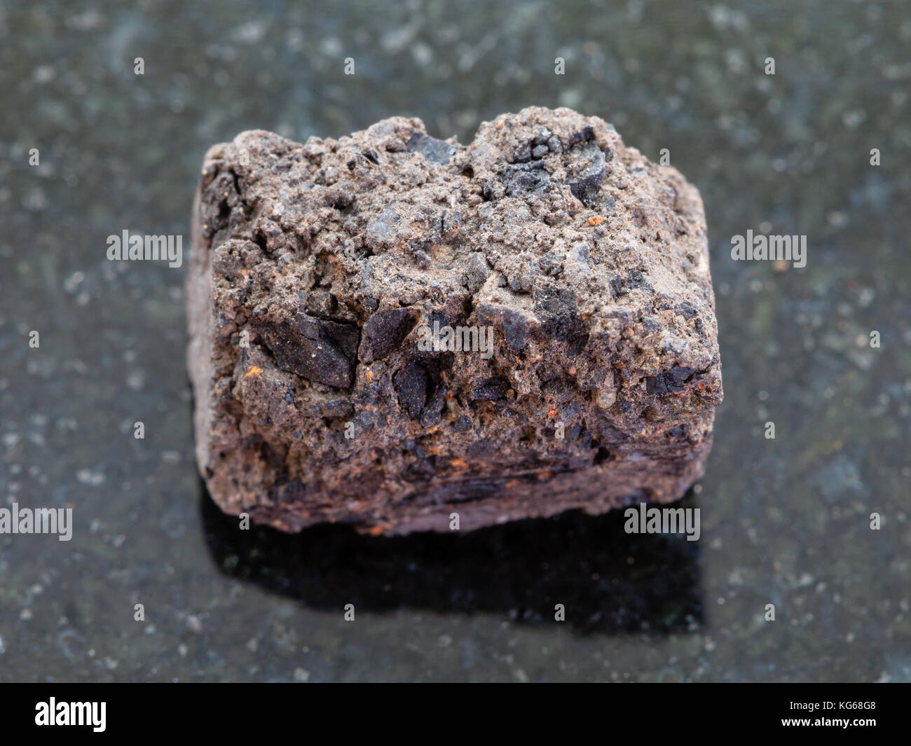 Le riprese in modalità macro di minerale naturale campione di roccia - materie torba turf sulla pietra di granito scuro dello sfondo Foto Stock
