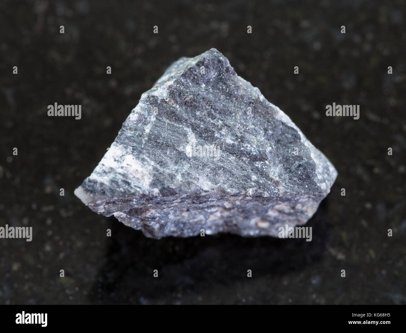 Le riprese in modalità macro di minerale naturale campione di roccia - materie stibnite (antimonite) minerale sul granito scuro dello sfondo Foto Stock