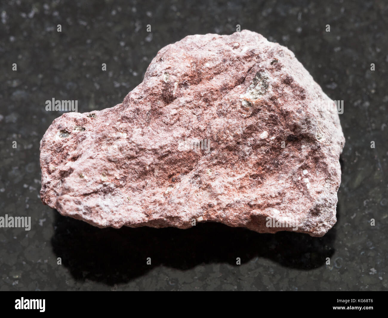 Le riprese in modalità macro di minerale naturale campione di roccia - Materie di cenere in pietra di tufo scuro su sfondo di granito Foto Stock