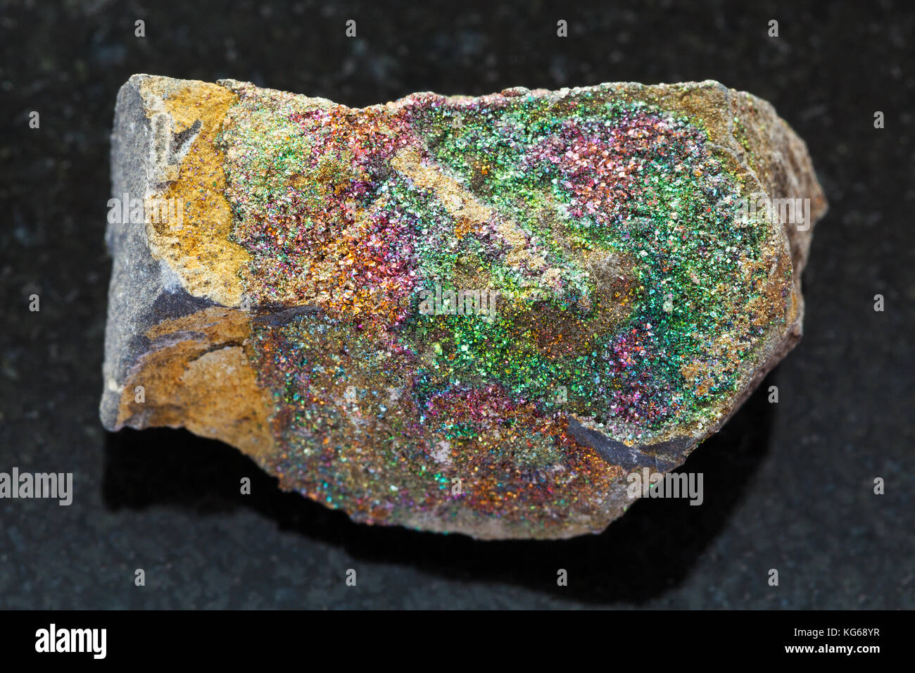 Le riprese in modalità macro di minerale naturale campione di roccia - arcobaleno ruvida pirite sulla pietra di granito scuro sfondo dalla regione di Ulyanovsk, Russia Foto Stock