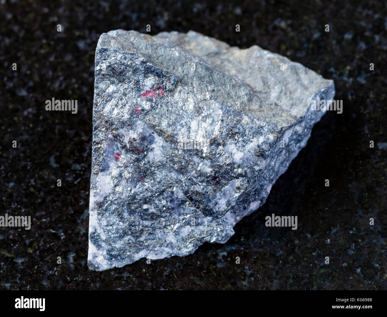 Le riprese in modalità macro di minerale naturale campione di roccia - materie antimonite sulla pietra di granito scuro dello sfondo chauvay dal distretto di Kirghizistan Foto Stock