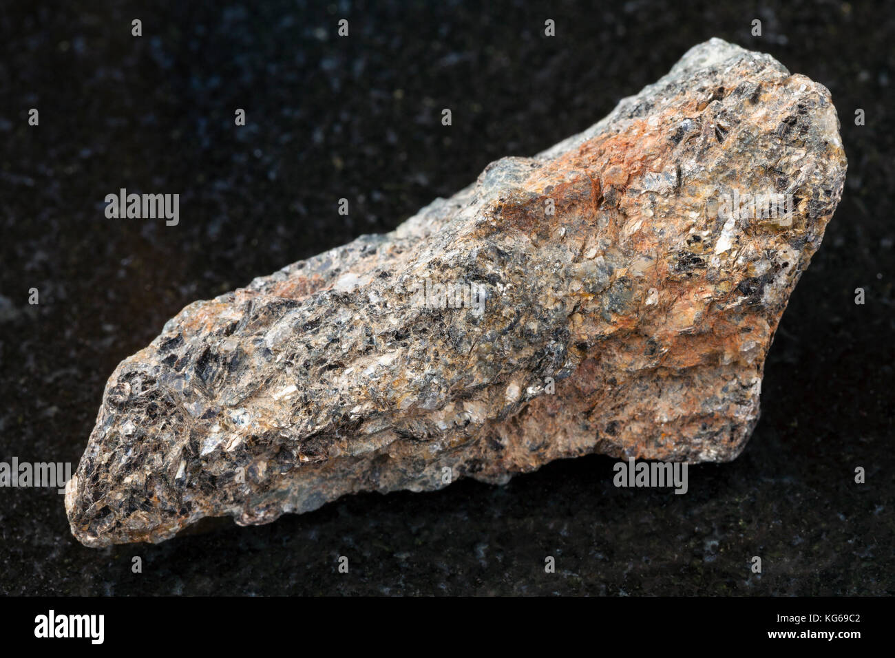 Le riprese in modalità macro di minerale naturale campione di roccia - materie biotite nefelina sienite sulla pietra di granito scuro dello sfondo Foto Stock