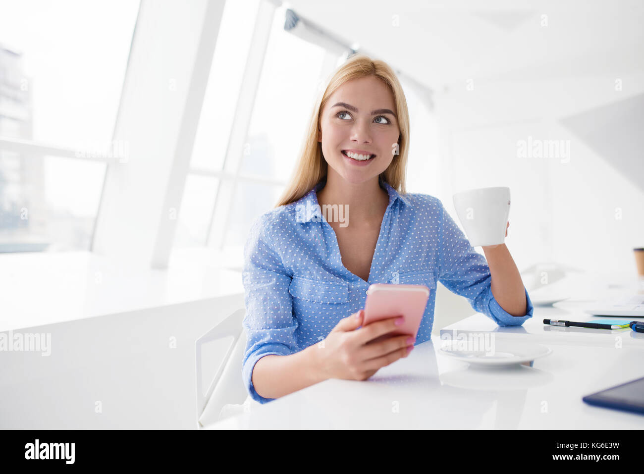 Donna felice prende una pausa caffè durante il suo lavoro Foto Stock