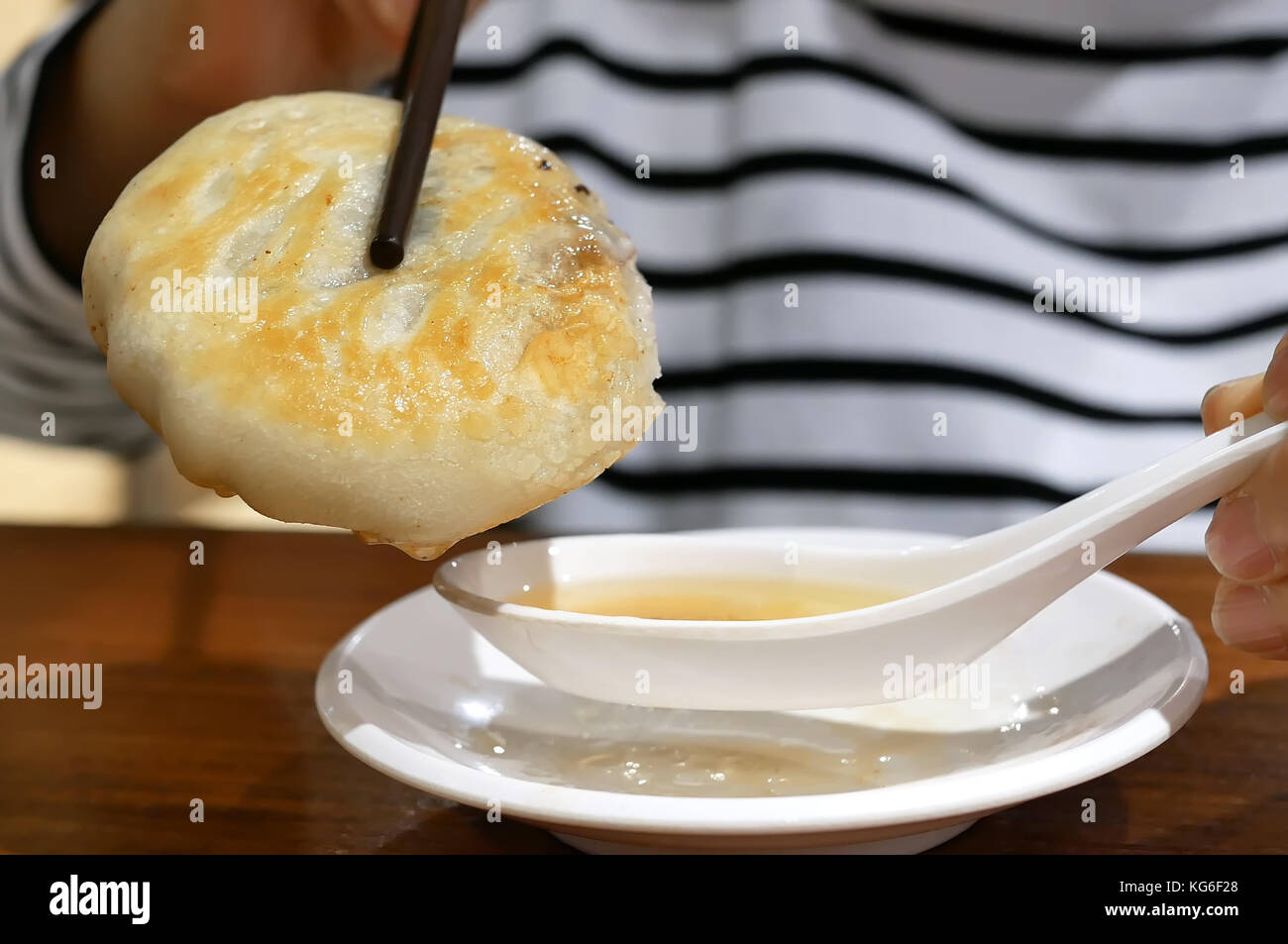 Close up donna mangiare carni bovine potpie e zuppa di immersione con cucchiaio ristorante interno Foto Stock