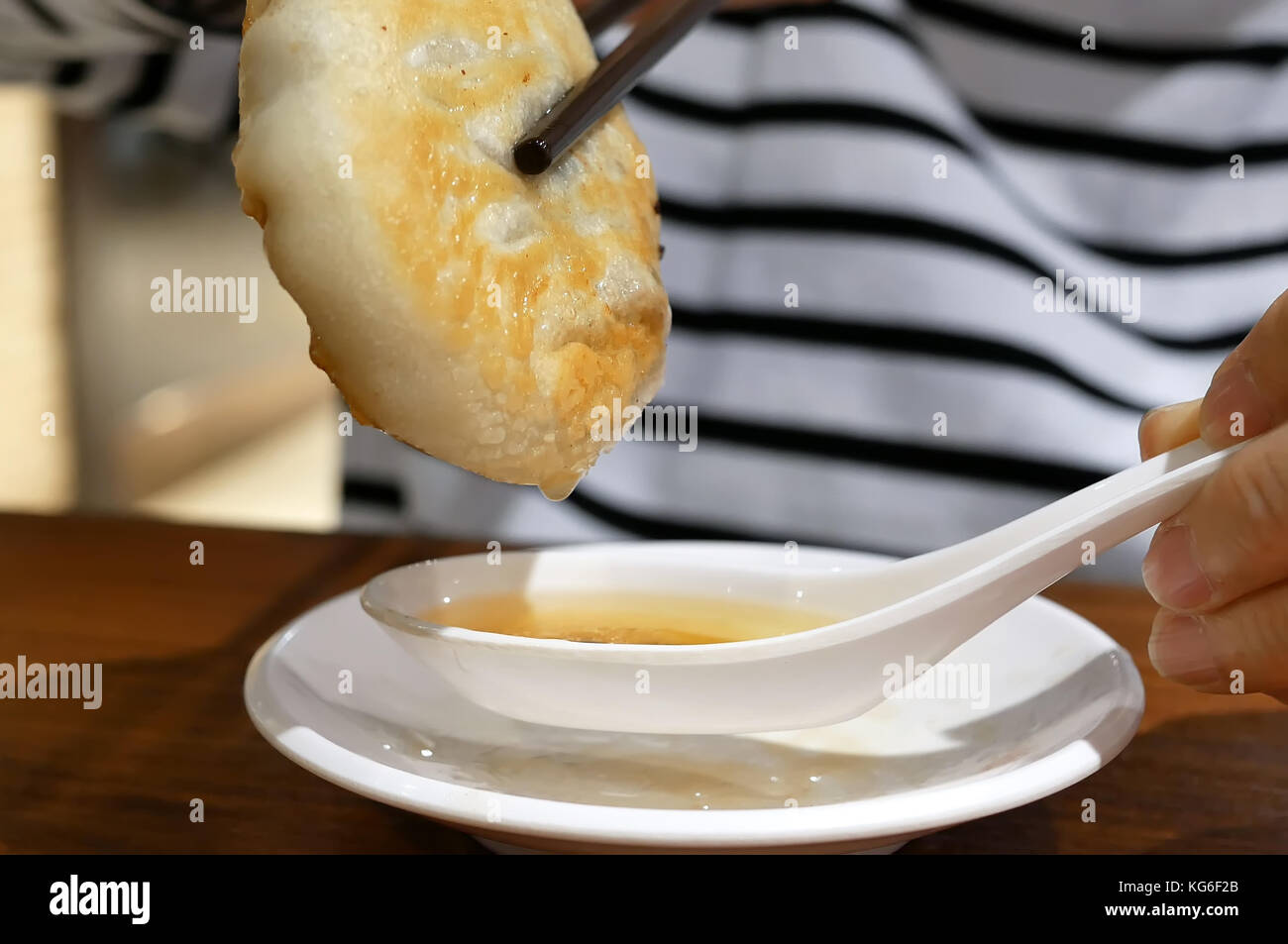 Close up donna mangiare carni bovine potpie e zuppa di immersione con cucchiaio ristorante interno Foto Stock