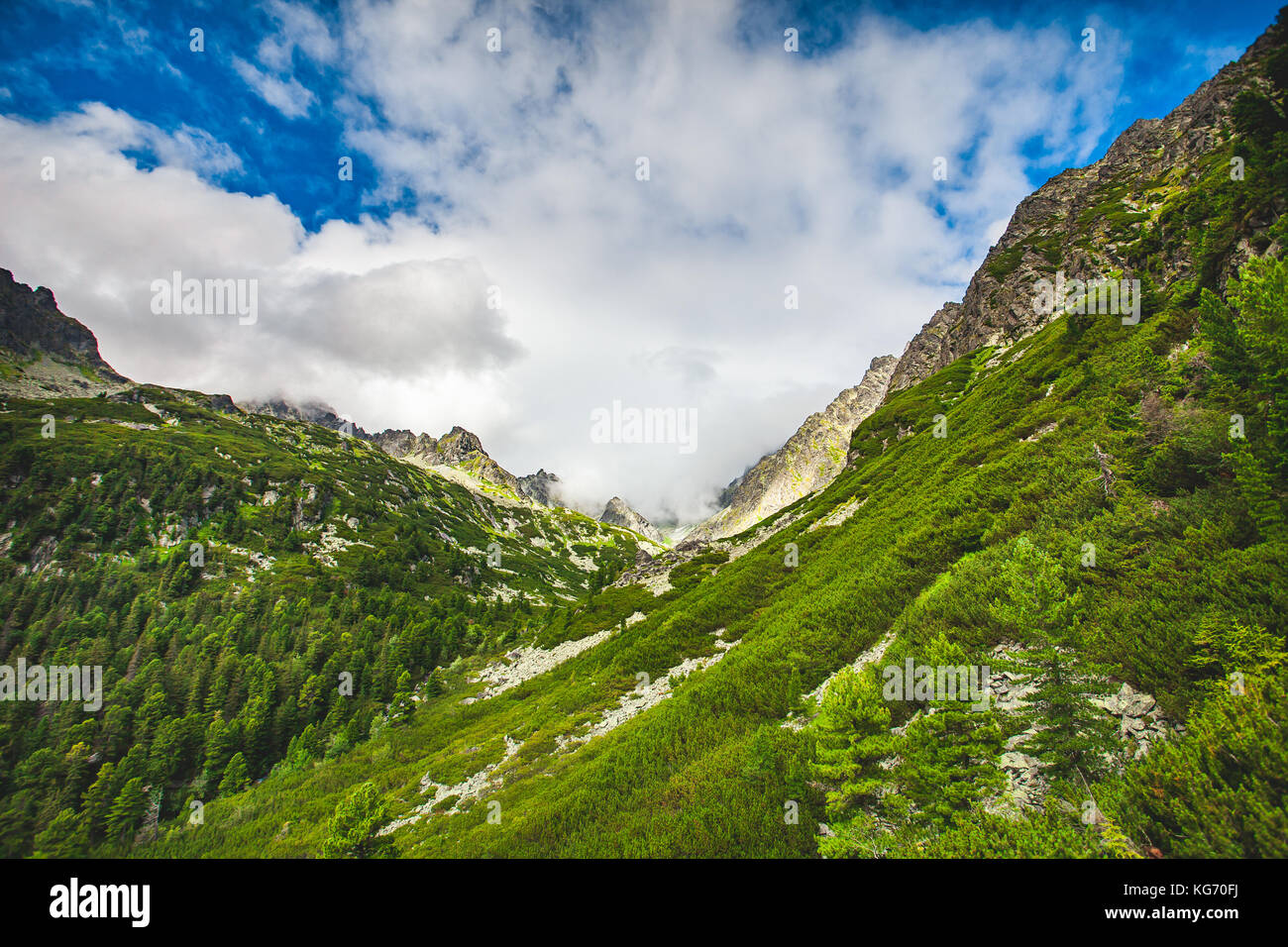 Montagna collina verde contro blu cielo molto nuvoloso Foto Stock